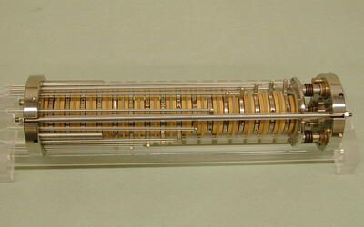 A cylindrical device is made up of adjustable disks with metal attachments on either end. 