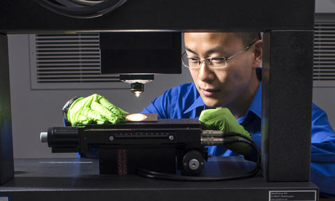 Zheng uses a 3D disc scanning confocal microscope to examine a chisel toolmark. (Photo copyright Robert Rathe.)