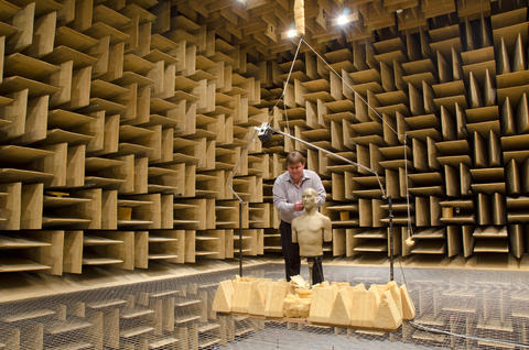 Randy Wagner prepares a standardized manikin for hearing aid testing in NIST's anechoic chamber.