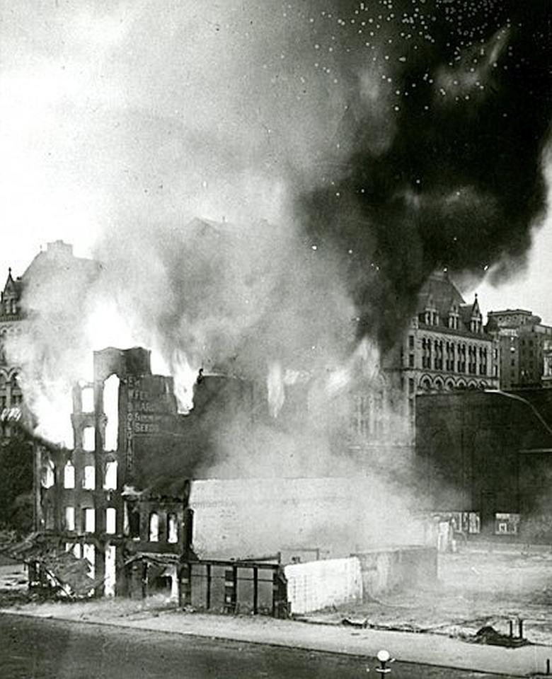 Black and white photo of office buildings burning in 1928.