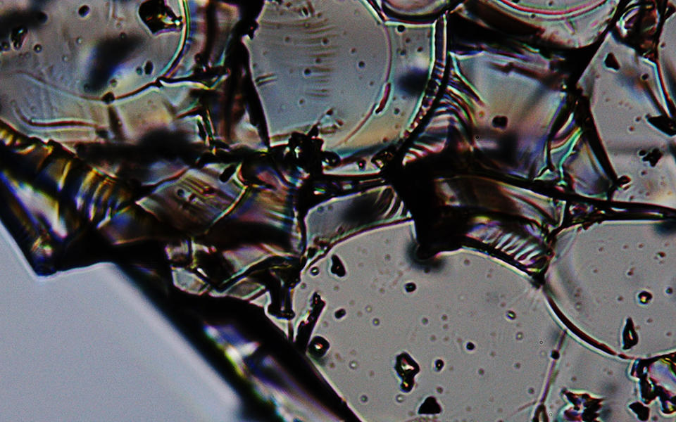close up of a clear fractured glass like substance with some rainbow distortions