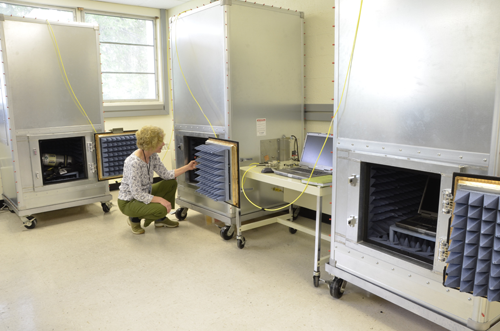Researcher Kate Remley examines the middle chamber containing a repeater unit in a "one hop" communications test. The PASS is in the cabinet at left, and the base station is in the cabinet at right.