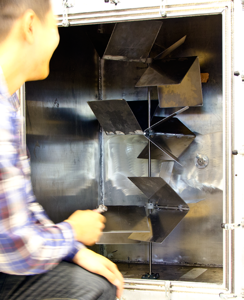 A researcher leans in to adjust the configuration of a controllable reflectivity chamber.
