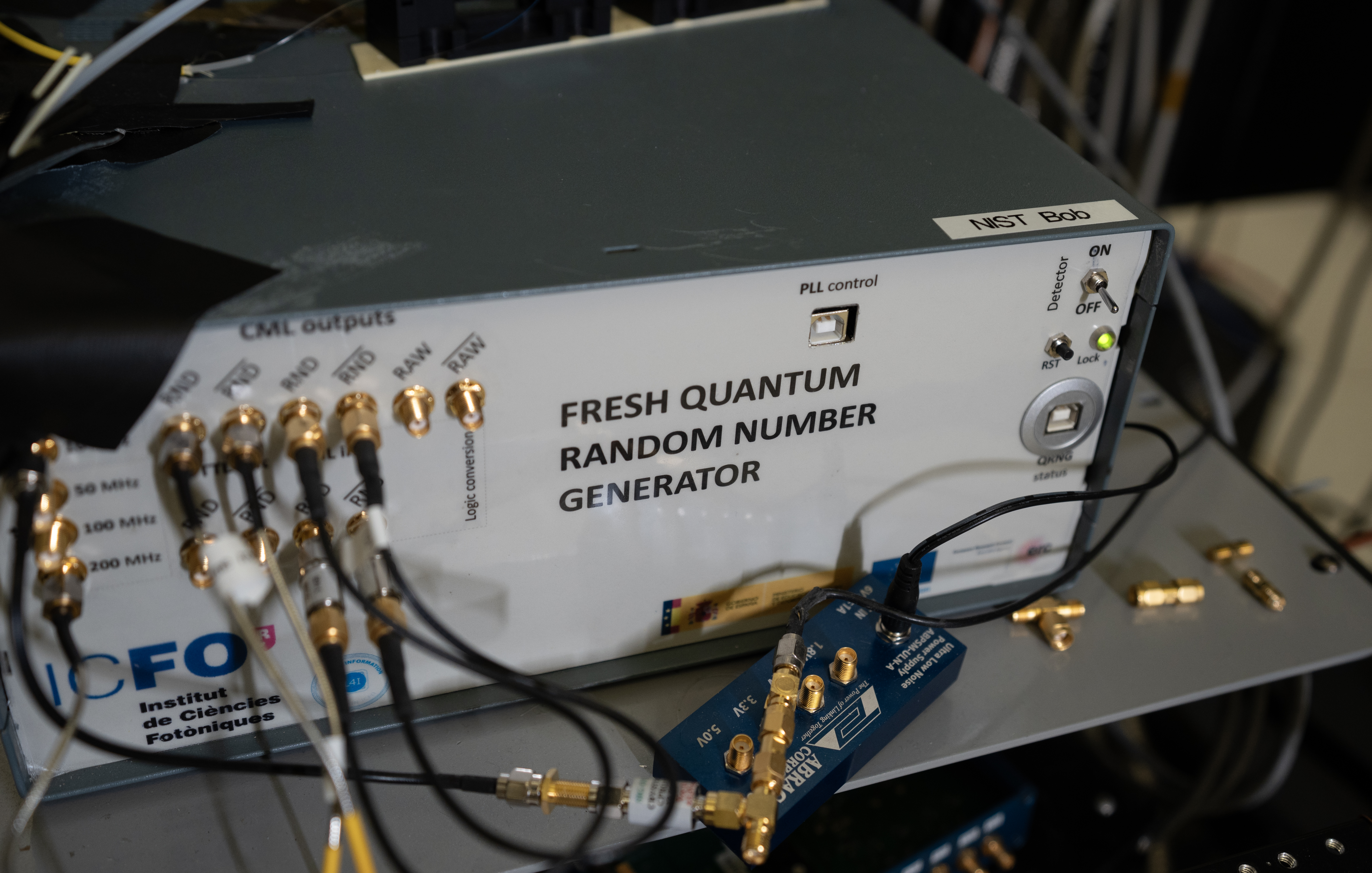 Box-shaped device with wires and connectors is labeled: Fresh Quantum Random Number Generator.