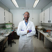 Man in a white lab coat standing in the middle of a lab
