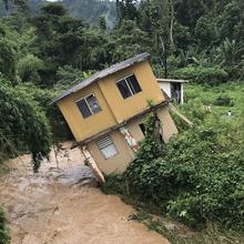 Home tilting into a river in Utuado, Puerto Rico