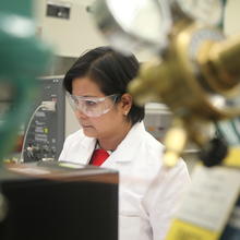 woman stands at mass spectrometer machine