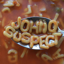 A spoon hovers above a bowl of alphabet soup. On the spoon are the letters JOHN Q SUSPECT. 