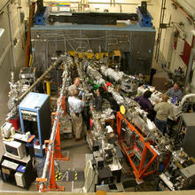 Overhead view of scientists standing among linear devices in a lab