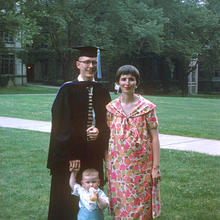 Jan Hall in a cap and gown with his wife and child receiving his PhD