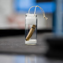 A copper bullet in a glass jar, sealed at the top.