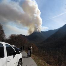 Onlookers view fire burning atop Chimney Tops mountain in Great Smoky Mountain National Park.