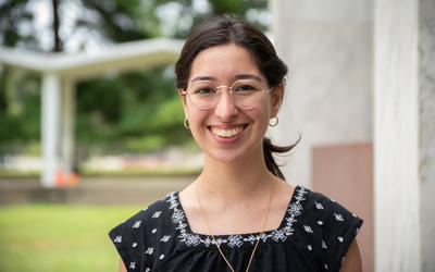 A headshot photo of summer intern Theresa Thomas standing outside on a patio at NIST’s campus.