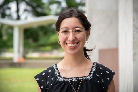 A headshot photo of summer intern Theresa Thomas standing outside on a patio at NIST’s campus.