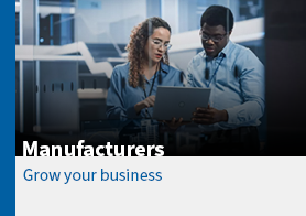 two people looking at a laptop in a factory