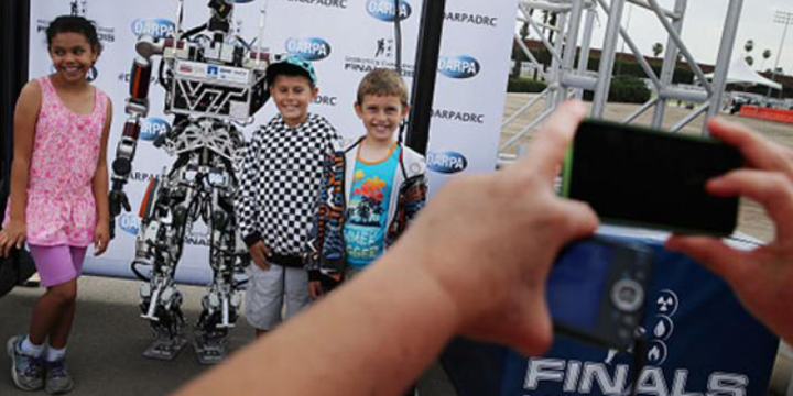 kids posing with a robot for a manufacturing video