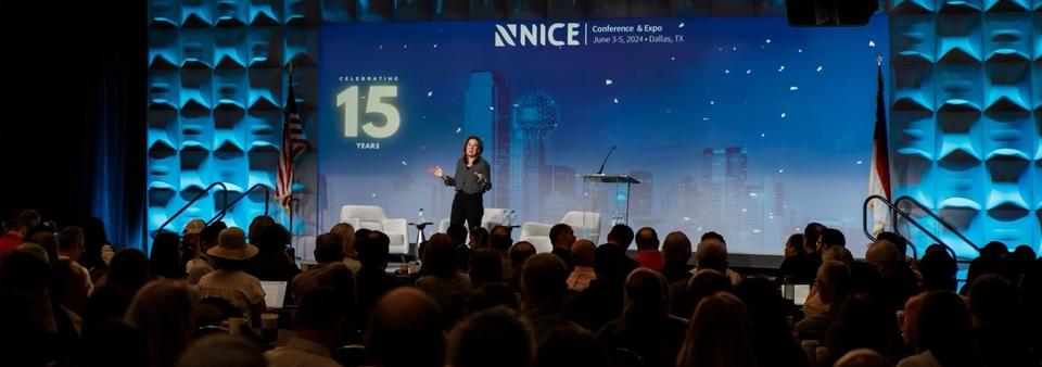 Speaker standing on the main stage at the NICE Conference