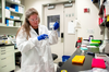 Researcher working in lab with safety glasses and gloves