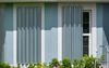 A home with hurricane shutters next to a ladder.