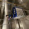 NIST researcher setting up air cleaner experiments in large stainless steel environmental chamber